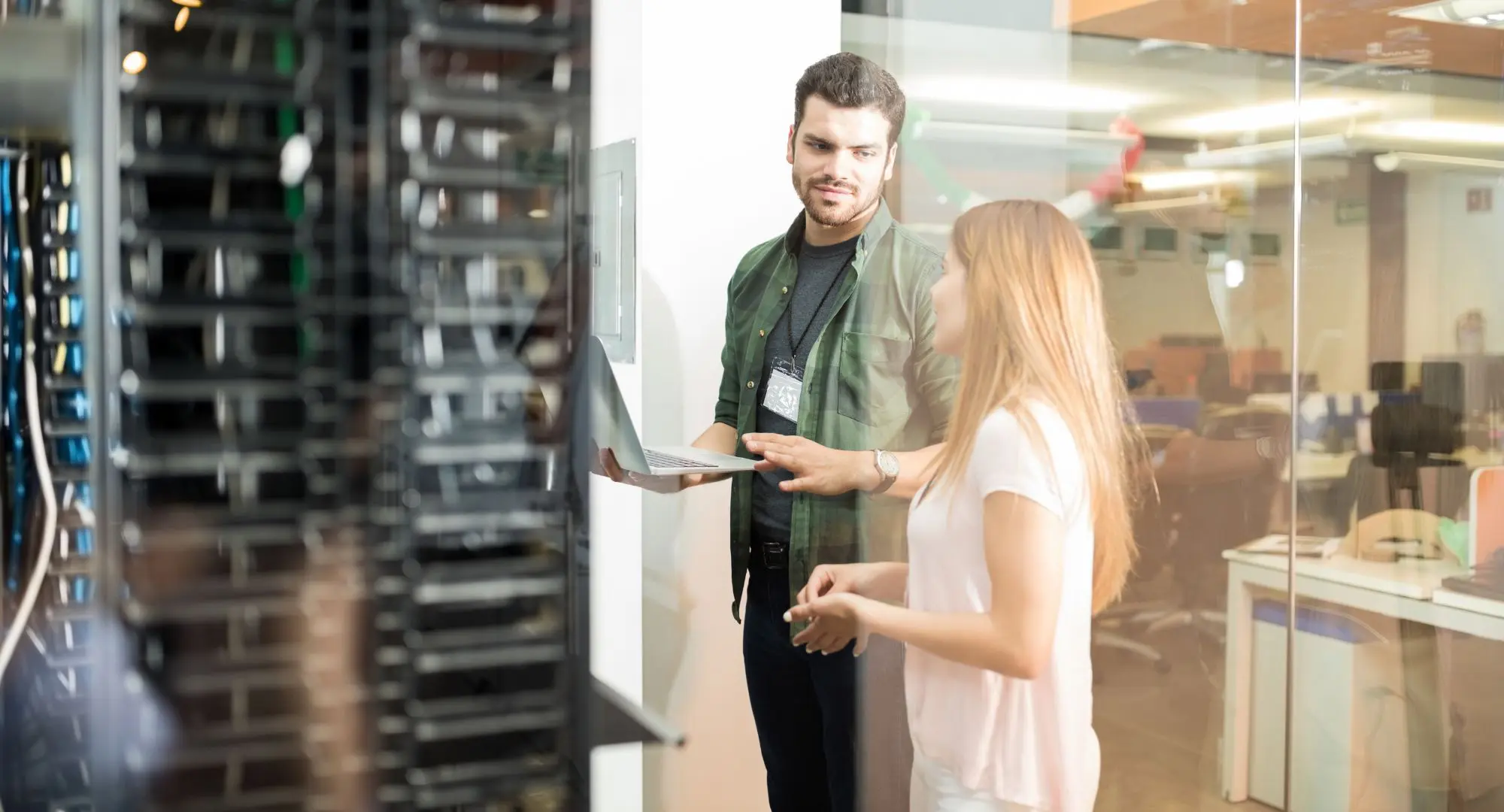Man and woman talking in server room about security